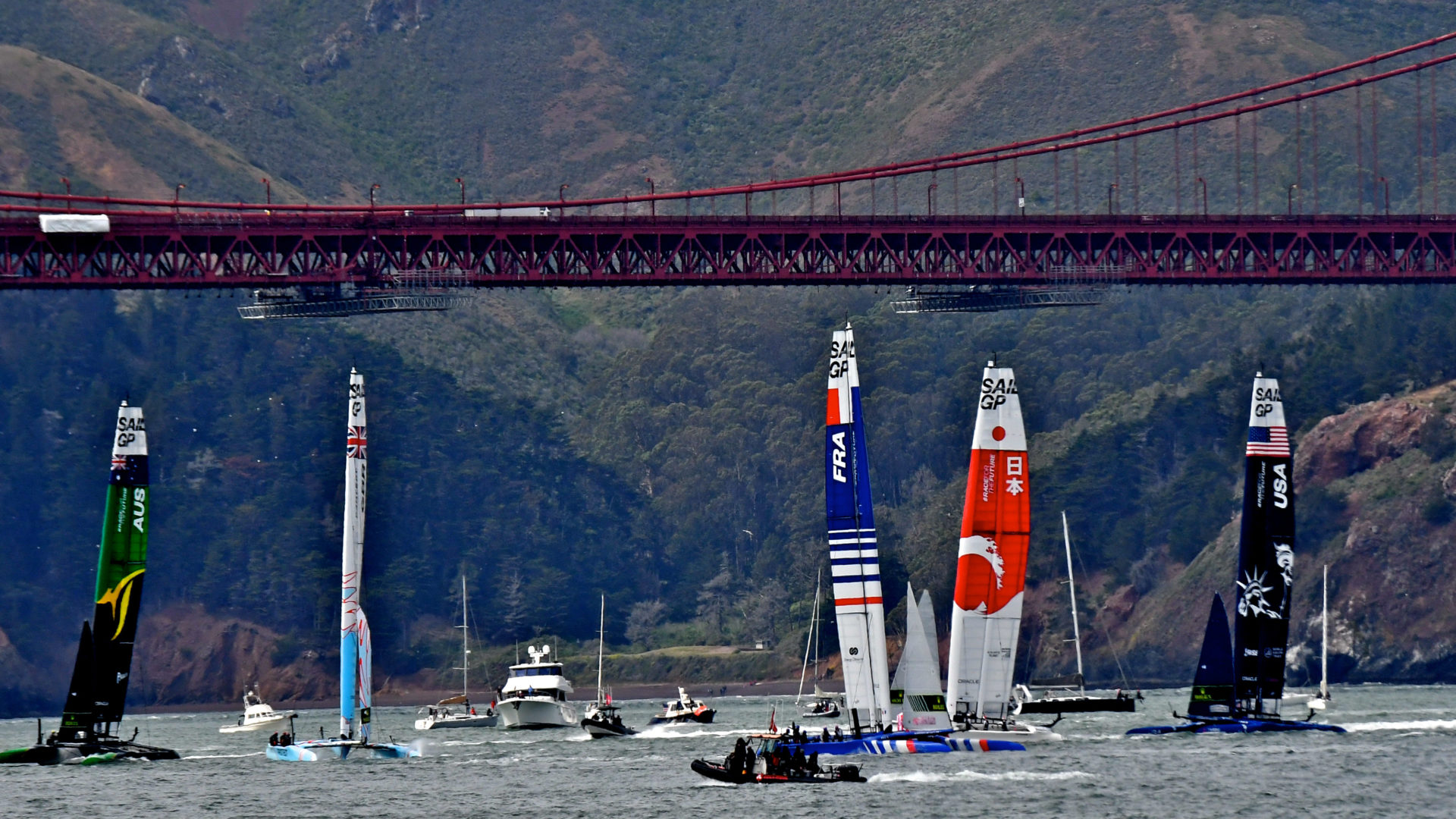 Sailboats on water, under a bridge